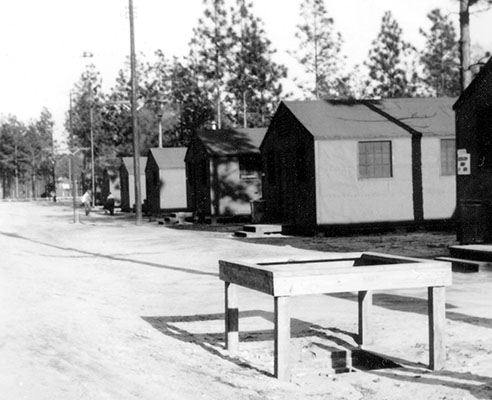 A “company street” at Camp Mackall, North Carolina with tarpaper-covered barracks buildings.