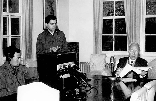 South Korean President Syngman Rhee records a speech for broadcast on the Korean Broadcast System. In the center of the photo is 1LT Eddie Deerfield. On the left is radio technician Lee Tuk Bin.