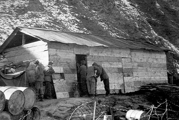 The supply building of the 2nd Partisan Infantry Regiment on Kangwha-do. The rugged terrain of the island and the snow of the Korean winter are evident in this photo from late 1953.