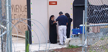 Two contracted role players prepare for a scenario with an Enhancement Coach (in dark shirt).
