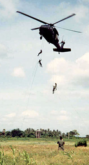Soldiers of the 1st Special Forces Group rappel from a 245th UH-60A Black Hawk.