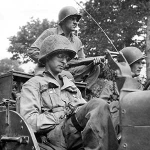 T/4 Norman Skeely of the 5th Ranger Battalion prepares a message for transmission back to the battalion headquarters in France, 17 August 1944. The fast moving Rangers used  vehicle mounted radios as well as man-pack systems. Strapped to his leg is the Morse Code key.