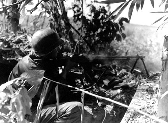 PVT Charles H. Pelsor of E Company, 2nd Battalion, 475th Infantry Regiment fires his BAR at retreating Japanese forces caught out in the open near Tonkwa, Burma, on 15 December 1944.