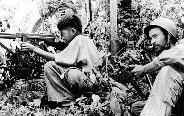 Kachin guerrillas could be as young as this twelve-year-old using a Thompson M1A1 submachinegun next to a Marauder in mid-1944.