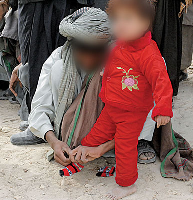 New clothing for a young Afghani. Providing supplies of food and clothing was instrumental in turning a passive population into one supportive of the Coalition effort.