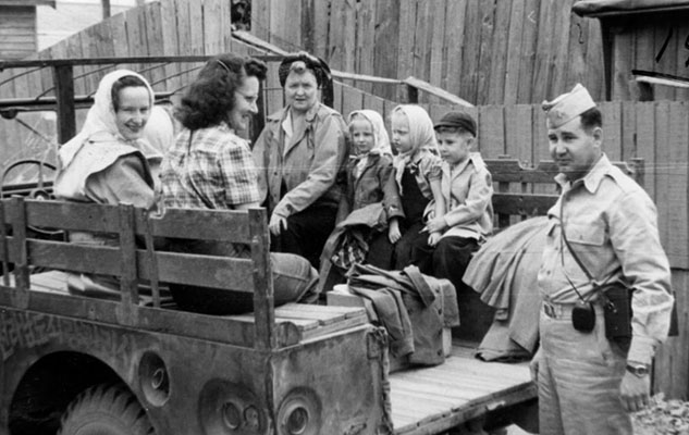101st Military Government Group families enroute to a picnic in the “family car” in Chonju, 1947. Mrs. Mary Vangen, Mrs. Novotney, Mrs. Curtis, two Vangen daughters in scarves (Sheryl and Sharon), unknown boy, and 1LT Novotney.