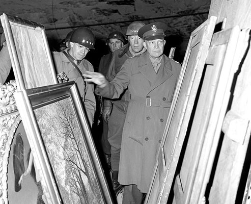 General Dwight D. Eisenhower, Supreme Allied Commander, inspects art looted by the Germans and stored away in the Merkers salt mine in Central Germany. Behind GEN Eisenhower are General Omar N. Bradley, CG, 12th Army Group, and LTG George S. Patton, Jr, CG, Third U.S. Army. 4/12/45.