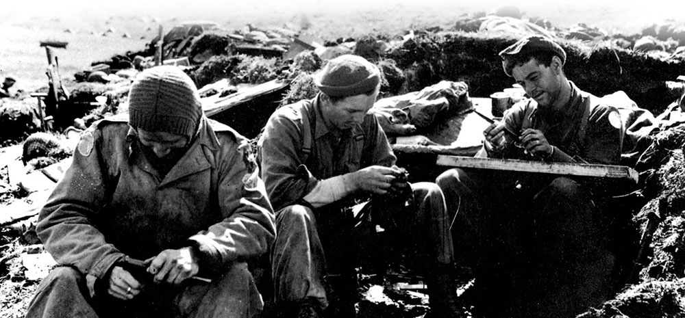 Forcemen rest and clean weapons following a patrol on Kiska. Despite the fact that the Japanese had evacuated the island before the invasion, the Force patrols were at risk from the overzealous Allied units that landed behind them.