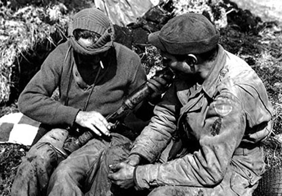 Two Forcemen examine a Japanese Type 89 50mm grenade launcher, known to the GI’s as a “knee mortar,” found during a patrol on Kiska. The man on the right is wearing both the First Special Service Force patch and that of ATF-9, “Corlett’s Long Knives.”
