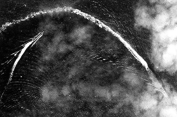 The Japanese aircraft carrier Akagi was sunk by aerial attack at the Battle of Midway. To the left a Japanese destroyer maneuvers to avoid the American aircraft. The defeat at Midway spelled the end of the Japanese expansion.
