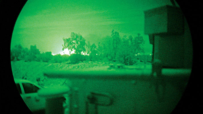 Night vision sight photo of airstrike on enemy compound.