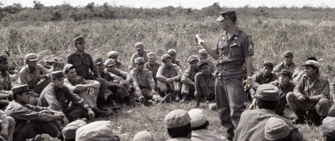 SFC Ethyl W. Duffield explains the 60 mm mortar to the Bolivians.