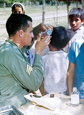 SGT Byron R. Sigg, a radioman, helps SSG Hapka with an ear exam.