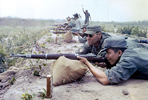 When the Special Forces team arrived to train the Bolivian Rangers, the standard infantry rifle was a Czech-made 7.62 mm Mauser. In the Ranger Battalion these were replaced with U.S. M-1 Garands and Carbines. Staff Sergeant Wendell Thompson trains a Bolivian infantryman with his Mauser on the range.