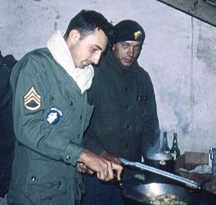 SSGs James Hapka (left) and Jerald Peterson cooking over a stove in the team quarters.