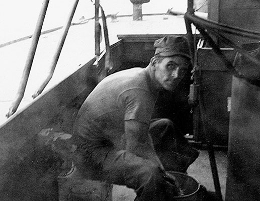 Sgt Willard R. Floyd, a mechanic in P-564’s engine room, cleans out one of the courtesy “comfort” buckets provided to the boat’s passengers.
