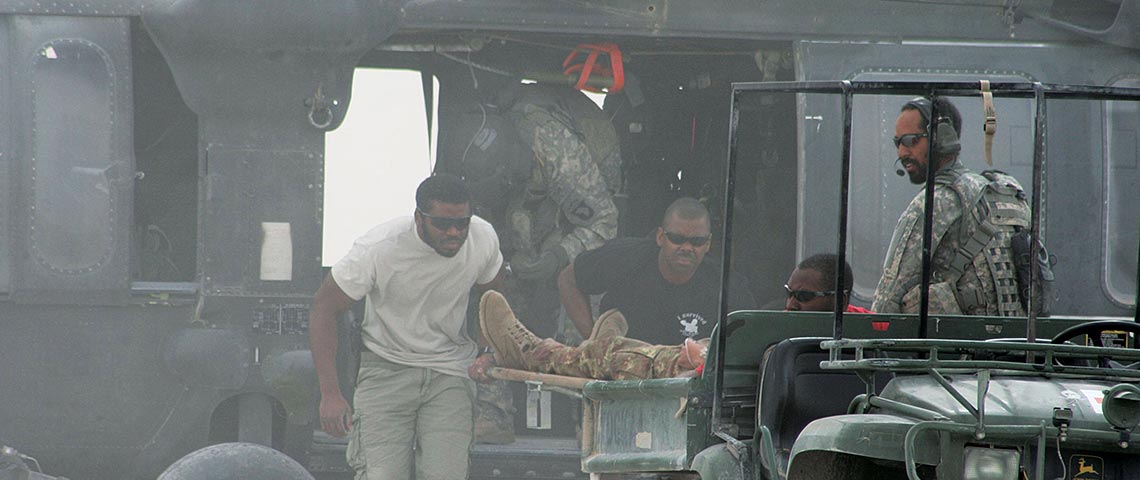 Specialist Donnell Smith, Sergeant Archer and Specialist Dwayne Bostic unload a casualty from the UH-60 MEDEVAC helicopter in Farah, Afghanistan.