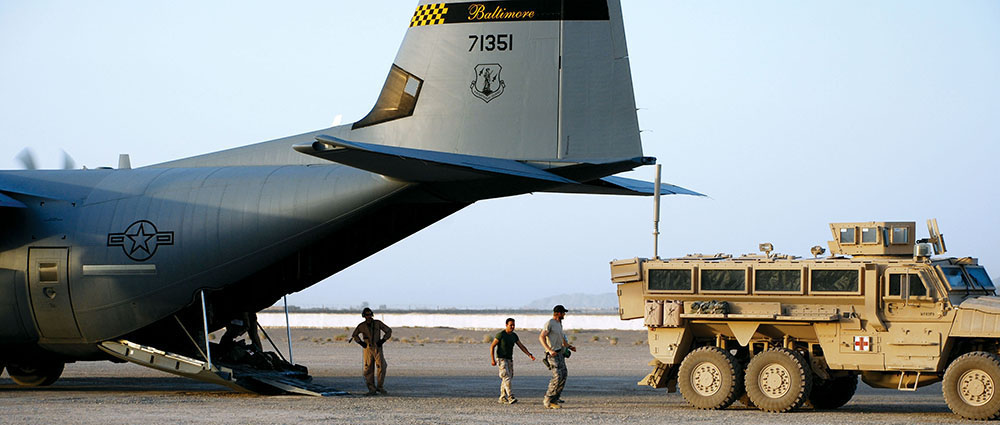 CPT Jamie Riesberg and Dr. Moreno from the Italian Coalition forces prepare to load a casualty from the Provincial Reconstruction Team’s MRAP (Mine Resistant Ambush Protected) ambulance onto a U.S. Air Force C-130 Hercules for evacuation to Bagram.