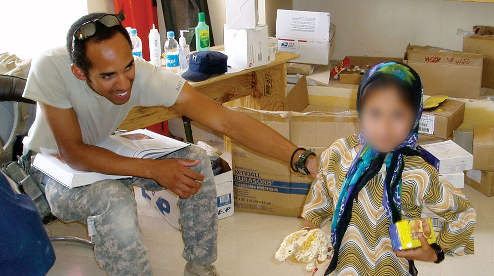 SSG Antujuan Brown, one of two Special Operations Combat Medics (SOCMs) on the SORT, treats a young Afghan girl at the weekly medical clinic.