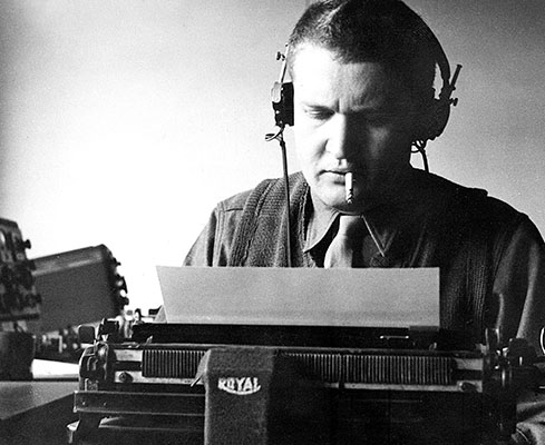An OSS radio operator transribes an incoming Morse Code message on a typewriter. He then decoded the text to read the message.
