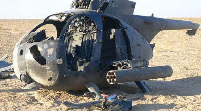 The crashed AH-6 in the desert. The pilots used fuel and ammunition from the aircraft to keep VALIANT 41 in the fight.