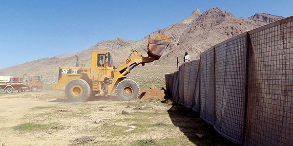 Filling the pre-fabricated HESCO barriers during the construction of the new checkpoint. The earth-filled barriers formed the protective walls.