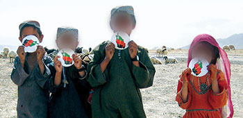 Children display their stickers of the Afghan National colors. Two Tactical PSYOP Teams from the 1st Battalion, 4th Psychological Operations Group supported the ARSOF mission in Deh Rawod by developing a variety of similar products promoting the Afghan government.