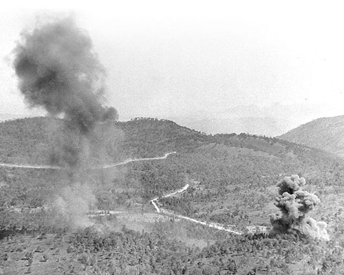 Directed by MARS Task Force observers, the USAAF bombs Japanese positions near the Burma Road. The road is seen in the middle foreground.