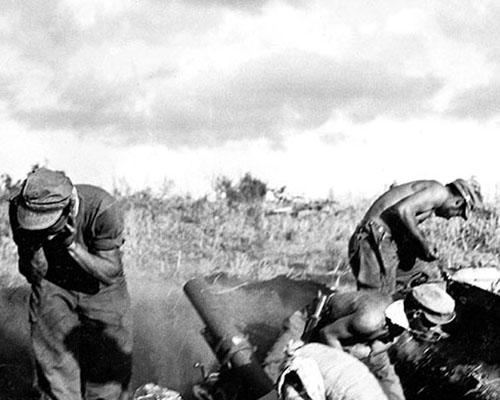 A 4.2 inch mortar crew fires on Japanese positions. Like the 75 mm pack howitzers, the 4.2 inch mortars were mule-packed.