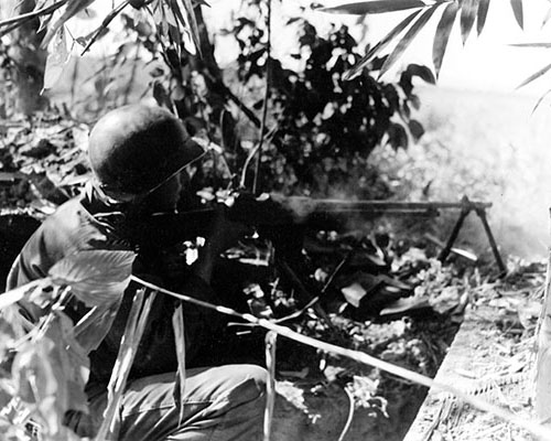 Private Charles H. Pelsor, E Company, 2nd Battalion, 475th Infantry, fires a Browning Automatic Rifle (BAR) at Japanese near Tonkwa on 15 December 1944.