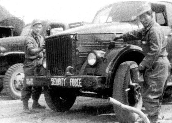 ISF Korean drivers paint a captured Russian-made Studebaker military truck.