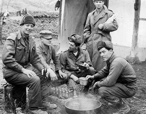 GHQ Raiders CPL Melvin J. McCarty, PFC George A. Barry, SFC Leslie A. Lepley, SGT Jamie F. Lee, and PFC John W. Connor engaging in a spirited discussion over Coca-Cola in Korea, 1951.