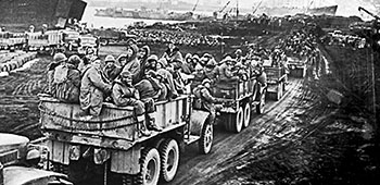 American troops entering Hungnam aboard trucks before the facility is blown up with demolitions.