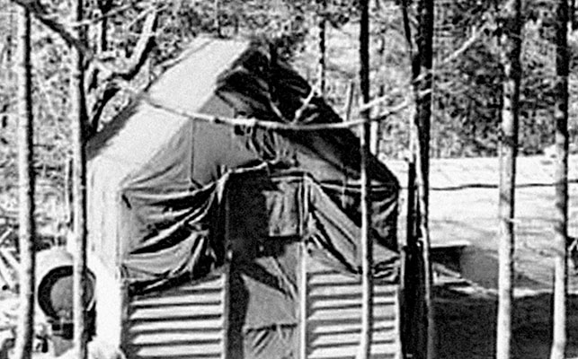 In “Paradise Pines” behind the Radio Pusan, the officers lived in a lone wood-framed tent. The Quonset huts where the soldiers were billeted are visible behind the tent.
