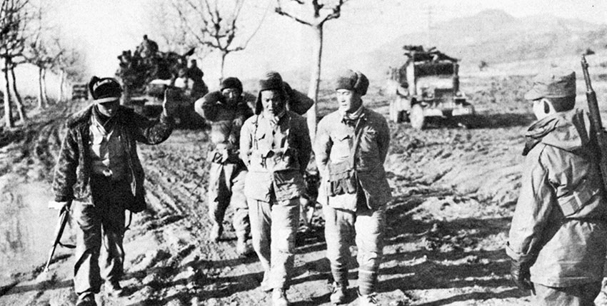 The Chinese Communist intervention in the Korean War in late 1950 again caught the Allies by surprise and forced them to relinquish their gains. Here South Korean troops bring four captured Chinese soldiers to the rear.