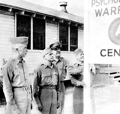 COLs Charles H. Karlstad and Aaron Bank with LTCs Lester L. Holmes  and John O. Weaver  pose by the Headquarters sign on Smoke Bomb Hill, Fort Bragg, NC.