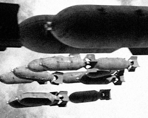 Rolled leaflets are loaded into 500 pound M16A1/2 Cluster Adapter Bombs.