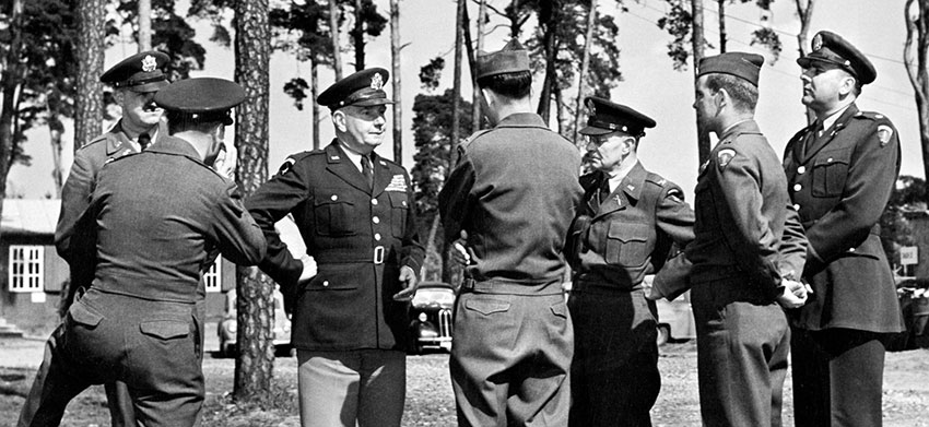 McClure meets with COL Ellsworth H. Gruber, commander of the 301st RB&L Group, CPT Leroy E. Peck, commander of the Reproduction Company of the 301st, and other Psywar officers in Germany in 1952.