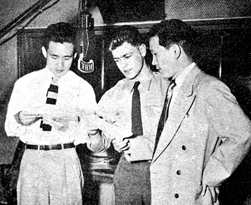 SGT George Menkart, 1st RB&L radio producer, goes over scripts with Korean actors in the studios of Radio Tokyo during a “mike-rehearsal.”