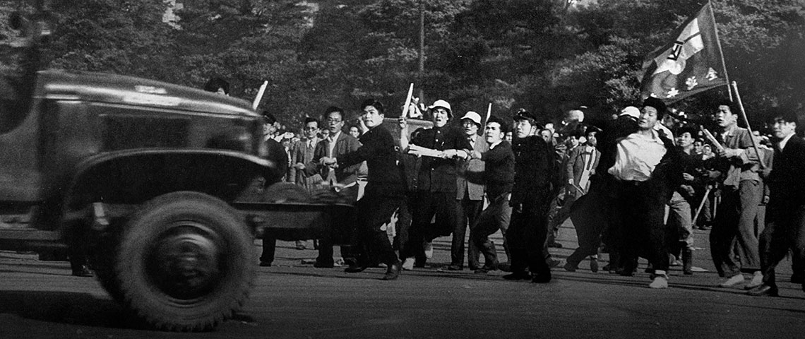 Lead Communist elements of the parade hurled a police barricade at a U.S. Army 6 x 6 truck by the Imperial Plaza.