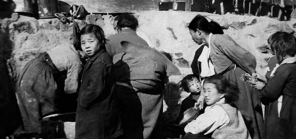 Korean refugees collect water from a common spring in Pusan (Fall 1951).