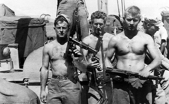 BM Warren Foley, SM Phillip E. Carrico, and SM B. Johnson, UDT-3, pose with Thompson sub-machineguns aboard the USS Diachenko