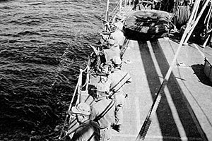 Enroute to their drop site the SMG raiders test fire their small arms from the bow of the Wantuck.