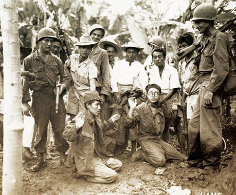 On Luzon Philippine guerrillas turn over two Japanese prisoners of war (POWs) to soldiers of the 25th Infantry Division