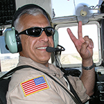 CW5 Arooji giving a peace sign while piloting a plane.