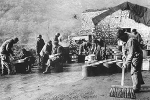 Service Battalion personnel man a field kitchen in the mountains of Italy. The round containers were used to transport hot food to the troops on the front lines. They were the predecessors to “Mermite” cans.