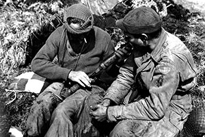 Two Forcemen examine a Japanese Type 89 50mm grenade launcher, known to the GI’s as a “knee mortar,” found during a patrol on Kiska. The man on the right is wearing both the First Special Service Force patch and that of ATF-9, “Corlett’s Long Knives.”