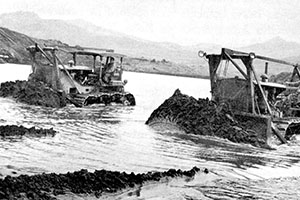Bulldozers dredging sand from Adak inlet to use as fill for the new airstrip. The ability of the U.S. forces to construct airfields in the Aleutians was a major factor in defeating the Japanese forces on the islands.