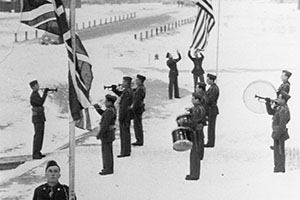US and Canadian soldiers forming the unit lower their respective flags at sundown, 1943