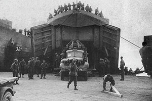 A FSSF Service Battalion 6 x 6 truck unloads from an LST (Landing Ship-Tank) at the Anzio beachhead.